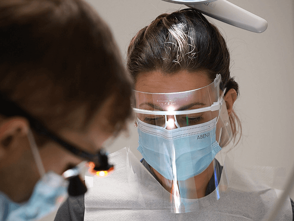 Tandhygienist utför puts och polering för att ta bort plack och missfärgningar.